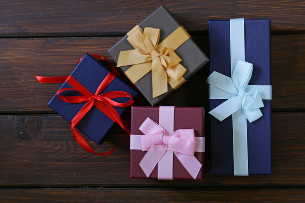 κουτιά δώρων με εορταστική κορδέλες σε ξύλινα φόντο - Φωτογραφία, εικόνα