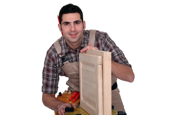 A carpenter working on a closet door. - Zdjęcie, obraz