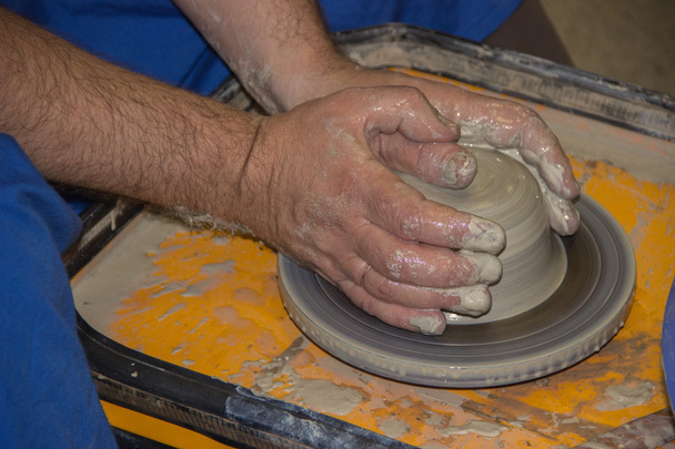Potter hace en la jarra de barro rueda de cerámica. Las manos de un potte
 - Foto, Imagen