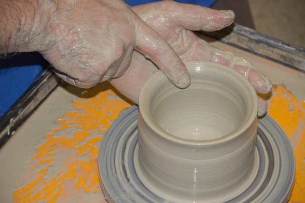 Il vasaio fa sulla brocca di argilla di ruota di ceramica. Le mani di una pentola
 - Foto, immagini