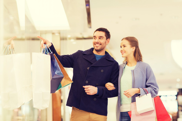 feliz pareja joven con bolsas de compras en el centro comercial
 - Foto, imagen