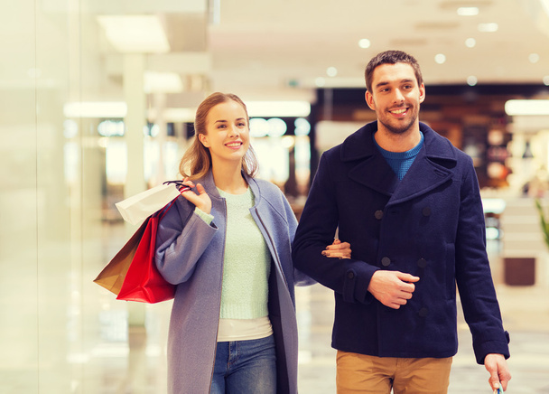 happy young couple with shopping bags in mall - Zdjęcie, obraz