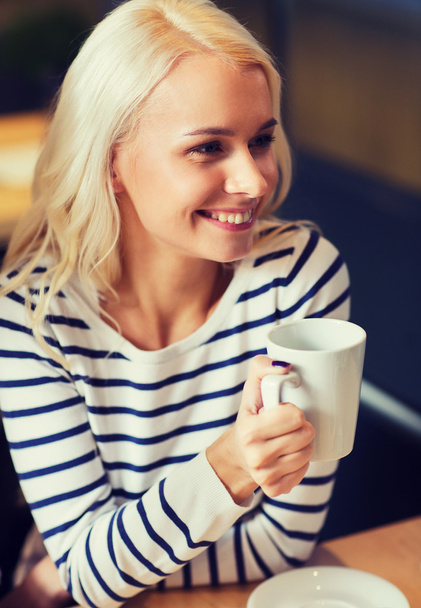 happy young woman drinking tea or coffee - Zdjęcie, obraz