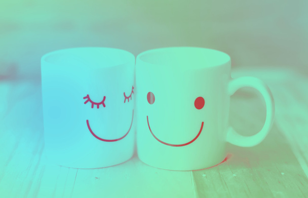 Две чашки счастья на деревянном столе с боке, о концепции любви
 - Фото, изображение