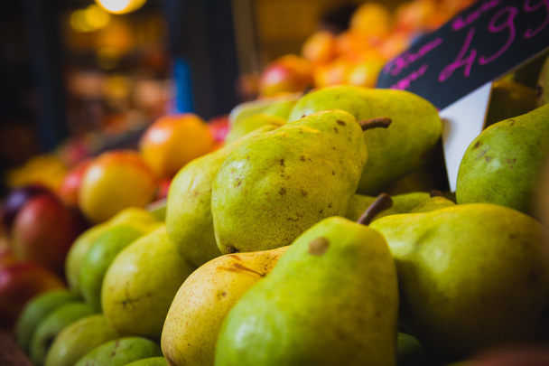 Pêras e pêssegos em uma banca de supermercado
 - Foto, Imagem