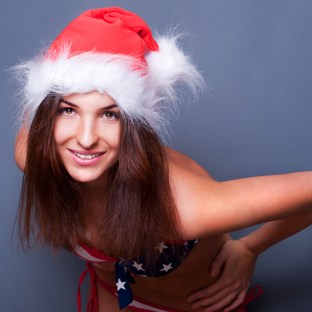 20-25 years old beautiful woman in christmas hat and swimsuit wi - Fotoğraf, Görsel