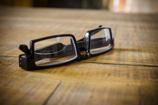 Черные очки для чтения на деревянном столе
 - Фото, изображение