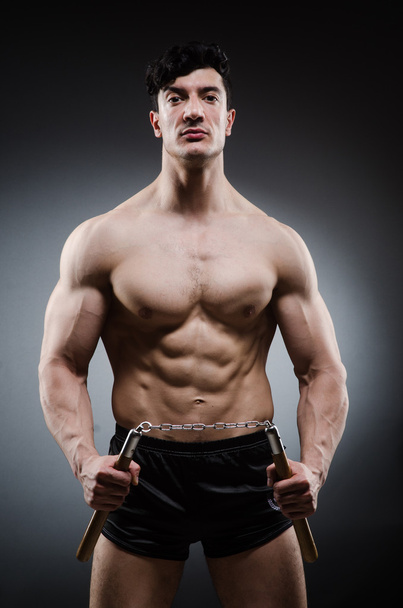 Muscular strong man with nunchucks - Foto, Imagem