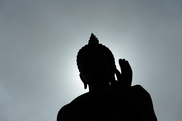 Силуэт статуи Будды с солнечным светом вечером
 - Фото, изображение