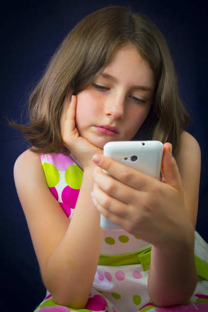 Portrait of beautiful little girl with cell phone - Фото, изображение