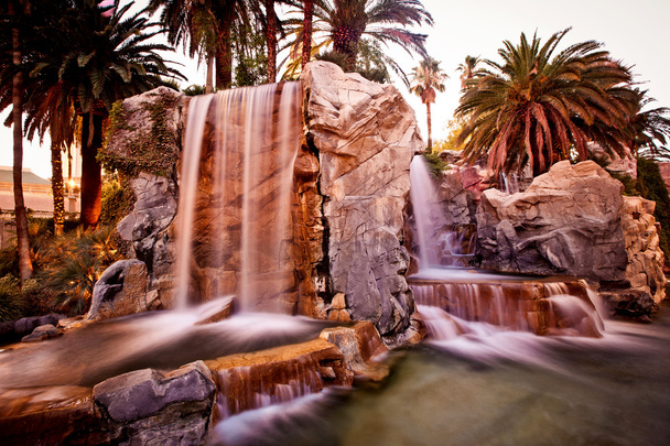 Artificial waterfall with palm trees - Фото, зображення