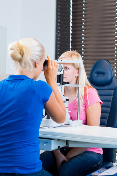 Pretty, young female patient having her eyes examined - Photo, image