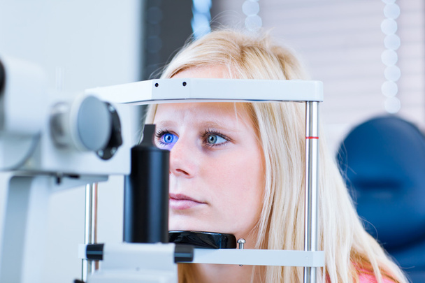 Pretty, young female patient having her eyes examined - Zdjęcie, obraz