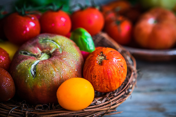 Multicolored tomatoes on rustic wooden background - Fotoğraf, Görsel