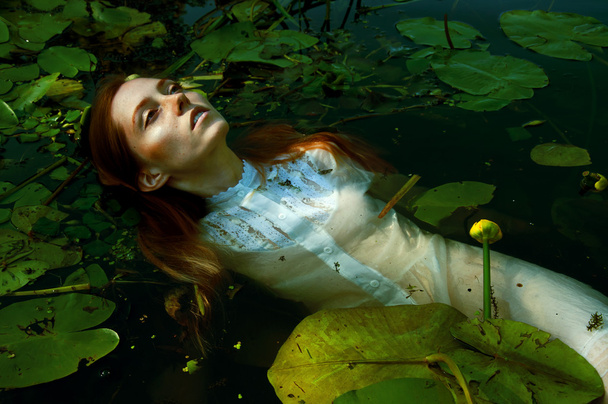 Нежная молодая женщина качается в пруду Амон водяные лилии
 - Фото, изображение