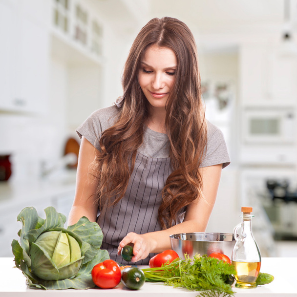 Genç kadın mutfakta yemek pişiriyor. Sağlıklı yiyecekler, sebze salatası. Diyet olsun. Diyet Konsepti. Sağlıklı yaşam tarzı. Evde Pişirme. - Fotoğraf, Görsel