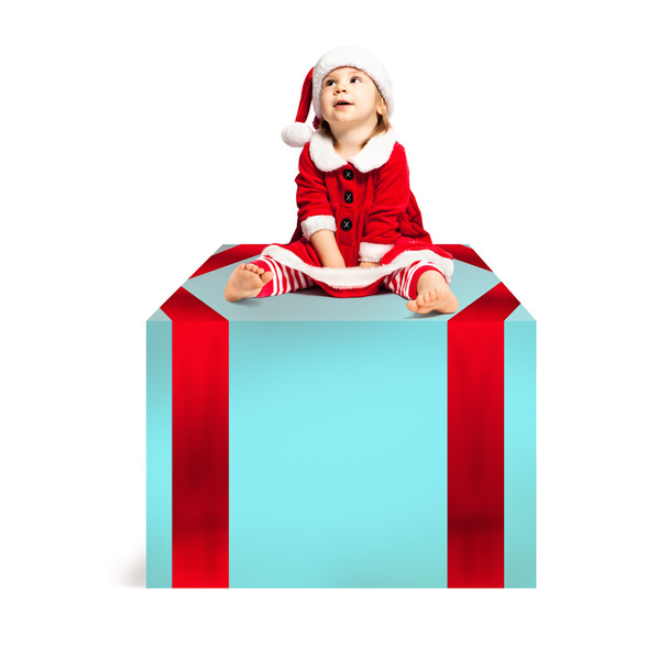 Weihnachtsbaby in Weihnachtsmütze auf großer Weihnachtsgeschenkbox sitzend. glücklich - Foto, Bild