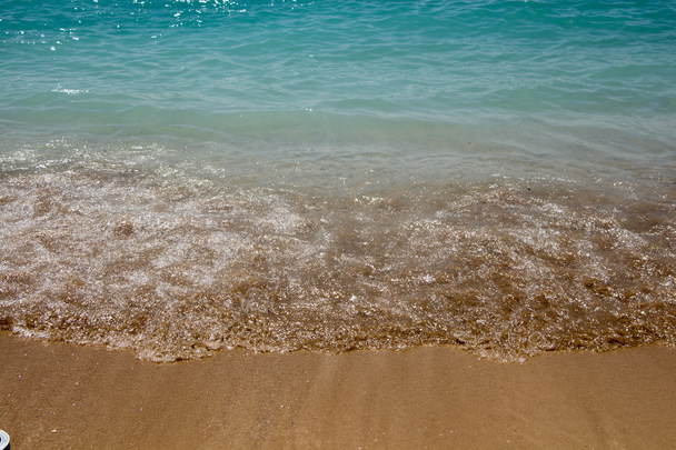 ターコイズ色の濡れた砂浜上のクローズ アップ - 写真・画像