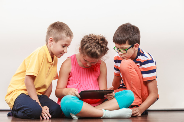 Kids playing on tablet. - 写真・画像