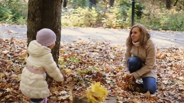 Moeder en dochter spelen samen in de herfst park - Video