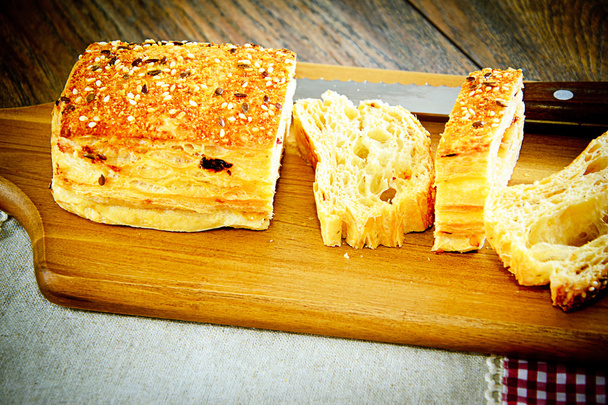 Sliced Bread with Sesame Seeds on a Wooden Board - Fotó, kép