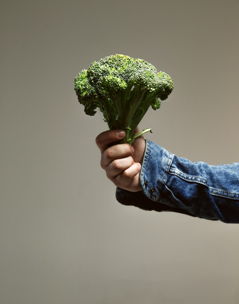 holding green brokoli. - Foto, Bild