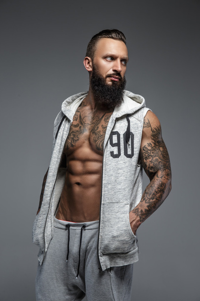 Hombre musculoso tatuado con barba
. - Foto, imagen