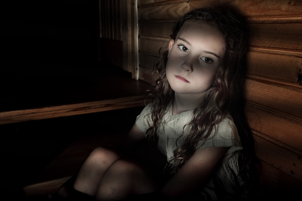 Depressed girl sitting in a dark hallway in home - Фото, изображение
