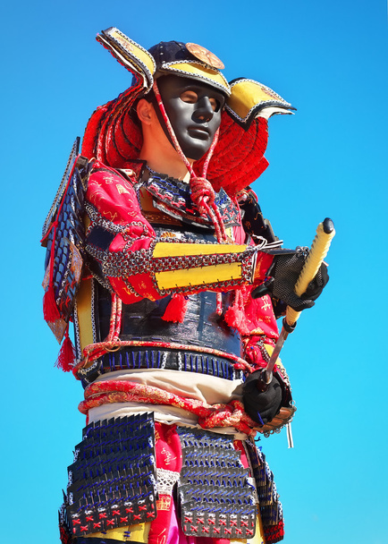 Людина в костюмі самурая з мечем на фоні блакитного неба
. - Фото, зображення