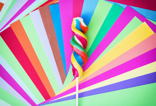 Πολύχρωμο στριμμένα γλειφιτζούρι γλυκό με χρωματιστά χαρτιά - Φωτογραφία, εικόνα