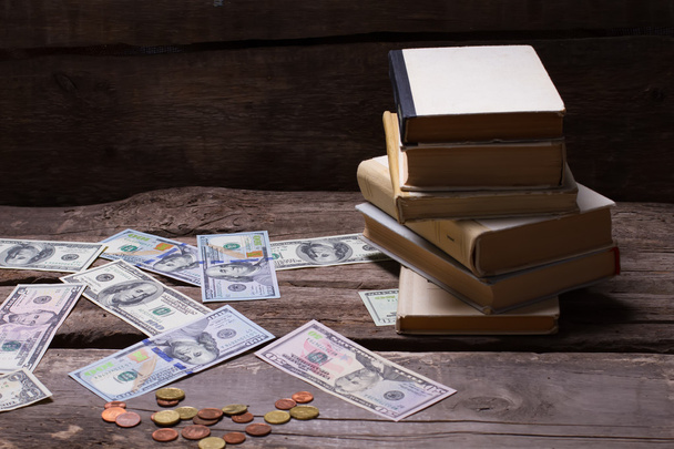 Old books and money on a vintage wooden background. - Photo, Image