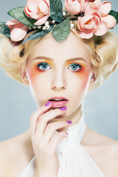 Lovely blonde super model in wreath of flowers and bright makeup - Fotó, kép