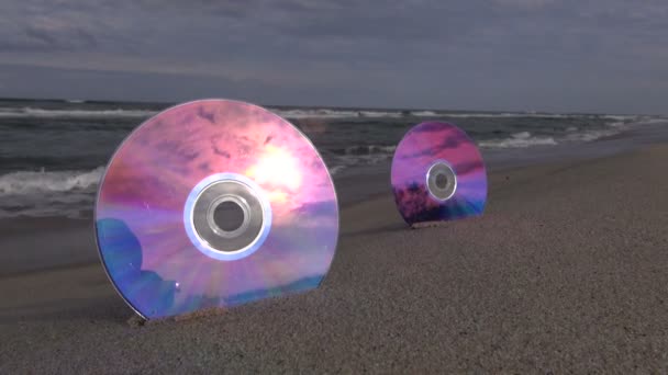 Paisaje marino con 2 DVDs en arena de playa de resort
 - Metraje, vídeo