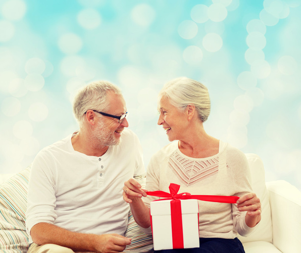 happy senior couple with gift box at home - Foto, imagen