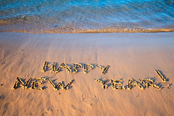 die Inschrift "Frohes neues Jahr" auf dem Sand. - Foto, Bild