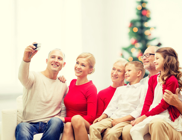 smiling family with camera at home - Valokuva, kuva