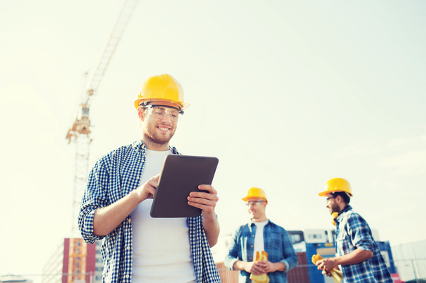 smiling builders in hardhats with tablet pc - Фото, зображення
