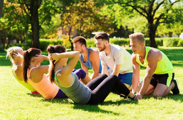 group of friends or sportsmen exercising outdoors - Foto, imagen
