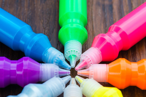 Пляшки з барвистими сухими пігментами на дерев'яному фоні
 - Фото, зображення