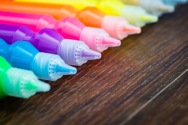 flessen met kleurrijke droge pigmenten op houten achtergrond - Foto, afbeelding