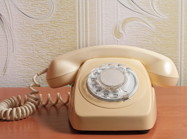 Retro telefoon op houten tafel in front achtergrond met kleurovergang - Foto, afbeelding