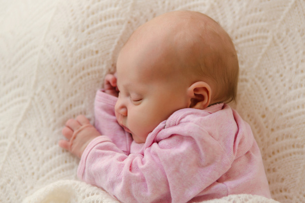 Nahaufnahme Neugeborenes schlafend auf weißer Decke zufrieden - Foto, Bild