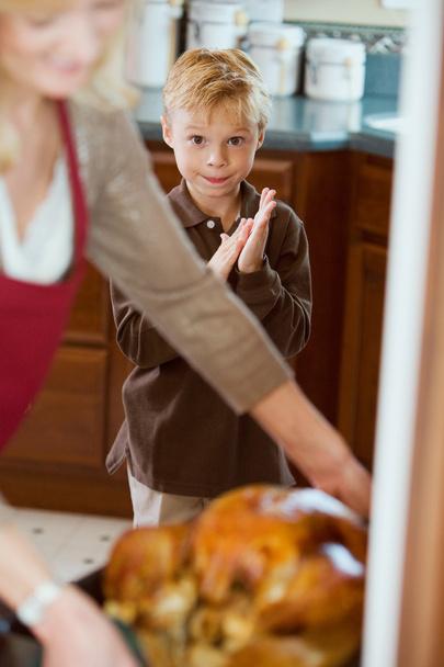 Thanksgiving: Hungry Boy Waits While Turkey Is Basted - Foto, immagini