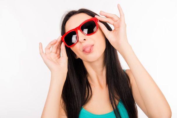 Funny young asian woman with red glasses showing tongue - Фото, зображення