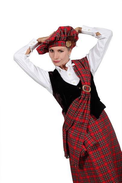 A young woman wearing a Scottish costume and looking at us. - Φωτογραφία, εικόνα