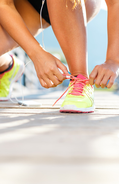 Zapatos para correr - mujer atando cordones de zapatos. Primer plano del deporte femenino
 - Foto, Imagen