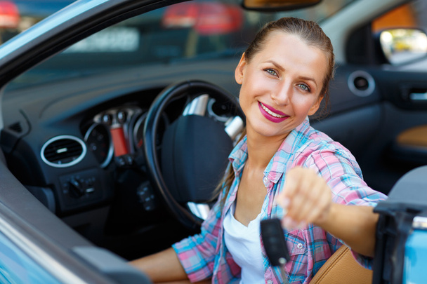 Mujer joven sentada en un coche descapotable con las llaves en la mano
 - - Foto, Imagen