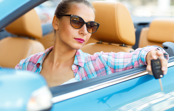 Femme en lunettes de soleil assis dans une voiture convertible avec les clés i
 - Photo, image
