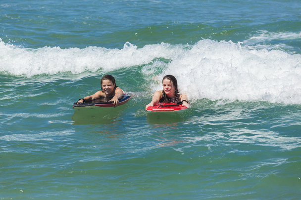 Meisjes surfen golven vakantie - Foto, afbeelding