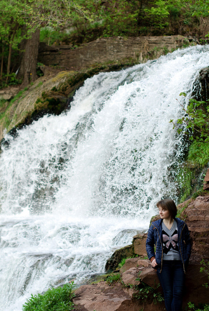 Giovane ragazza in piedi vicino cascata foresta. Sognando
 - Foto, immagini